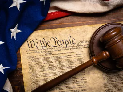 Judge’s gavel and the U.S. Constitution, symbolizing justice, constitutional rights, and legal defense.
