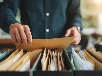 Person searching through file folders for court records or case documents