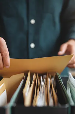 Person searching through file folders for court records or case documents
