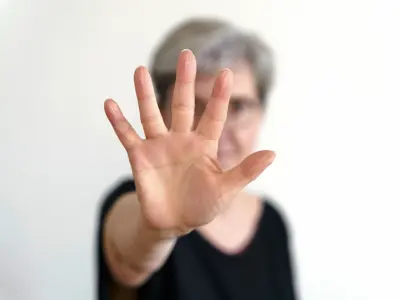 Person raising hand to signal stop or set a boundary